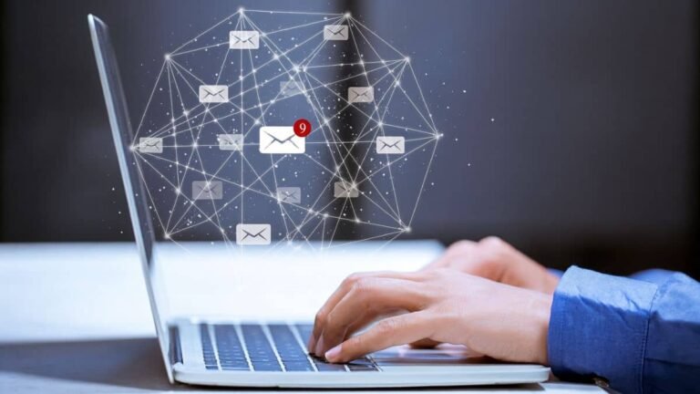 Typing on laptop with email icons connected in a digital network showing message notifications